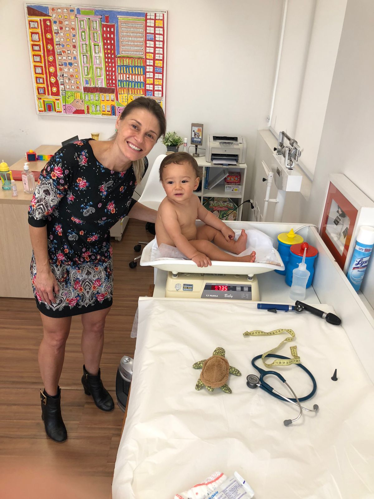 Dra. Milena pesando bebê na balança do consultório