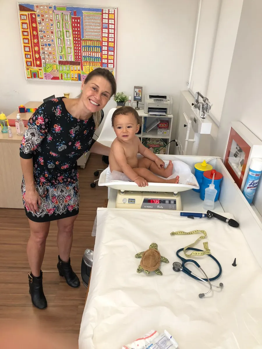 Dra. Milena pesando bebê na balança do consultório
