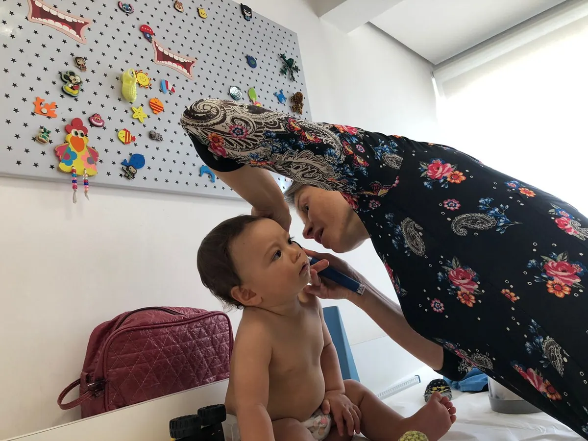 Dra. Milena examinando bebê no consultório